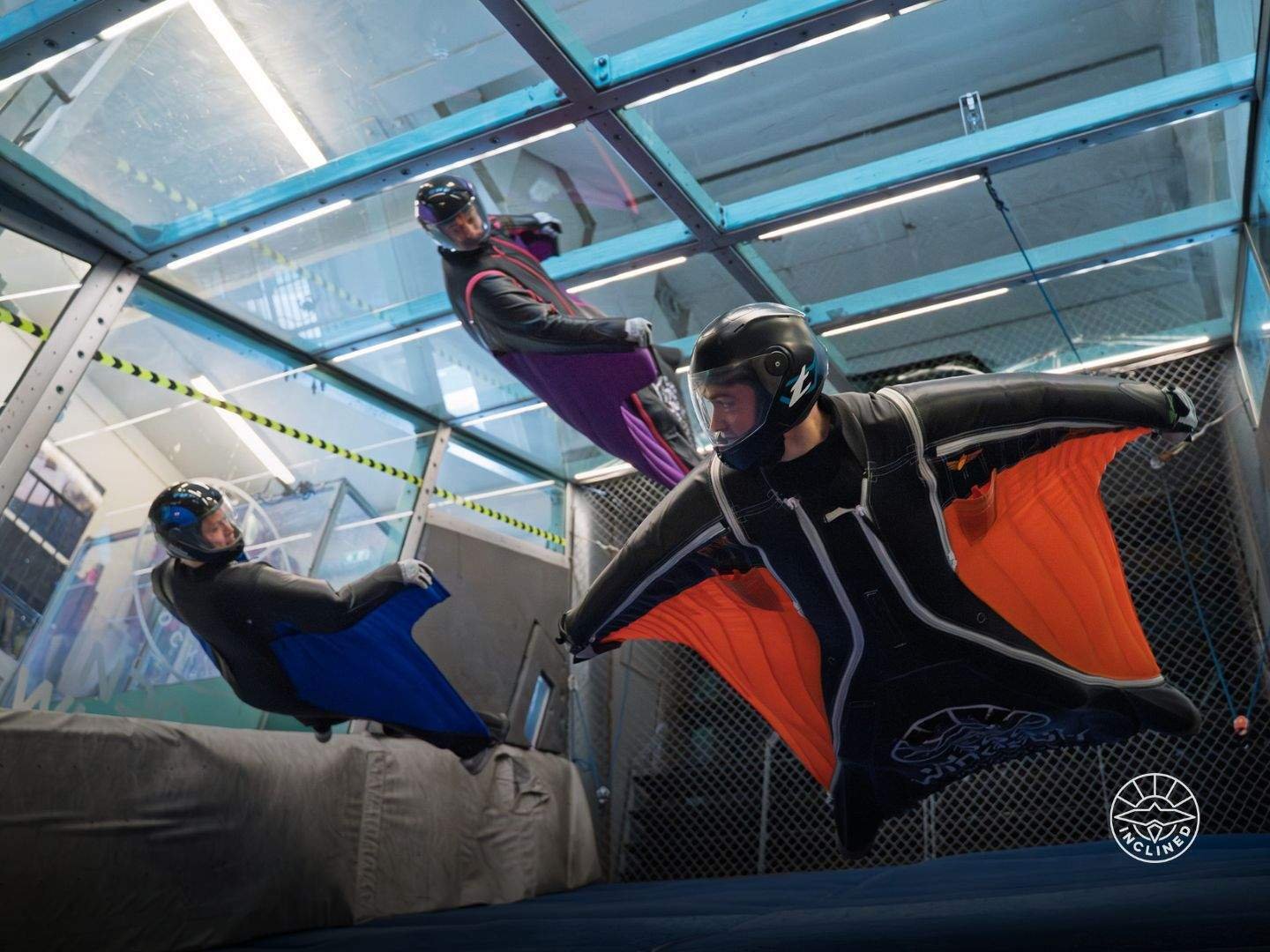 Experienced proflyer performing advanced manoeuvres inside the inclined wingsuit tunnel with strong body control.