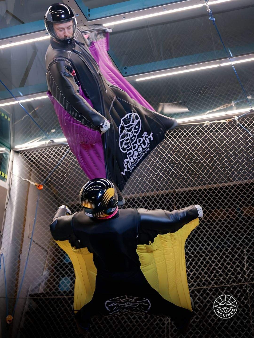 Experienced proflyer performing advanced manoeuvres inside the inclined wingsuit tunnel with strong body control.